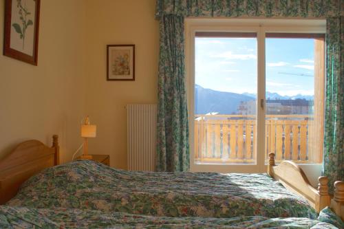 a bedroom with a bed and a window with a view at Central & Spacious, Richemont in Crans-Montana