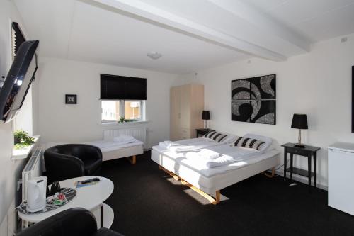 Skagen Hotel Annex في سكاغن: غرفة فندقية بسريرين وتلفزيون