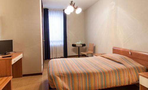 Habitación de hotel con cama y TV en Albergo Michielini, en Spilimbergo