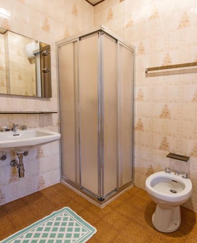 a bathroom with a shower and a toilet and a sink at Albergo Michielini in Spilimbergo