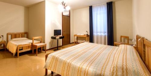 um quarto de hotel com duas camas e uma televisão em Albergo Michielini em Spilimbergo