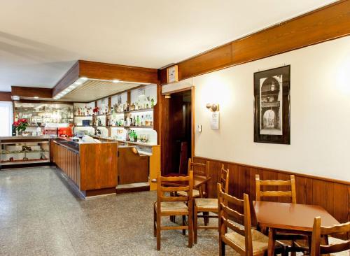 un restaurante con mesa, sillas y barra en Albergo Michielini, en Spilimbergo