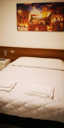 a white bed with two white towels on it at Il Glicine in Verona