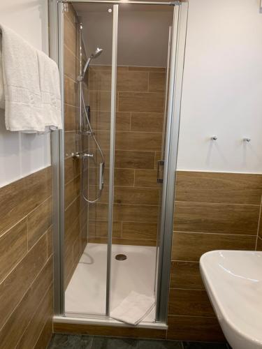 a shower with a glass door in a bathroom at Marias Inn - Bed & Breakfast in Garching bei München