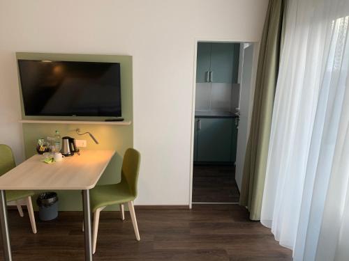 a dining room with a table and a television on the wall at Marias Inn - Bed & Breakfast in Garching bei München