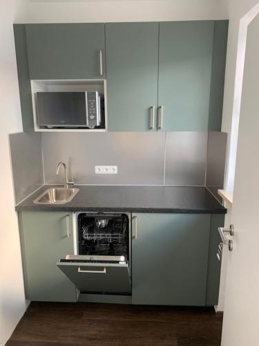 a small kitchen with a sink and a microwave at Marias Inn - Bed & Breakfast in Garching bei München