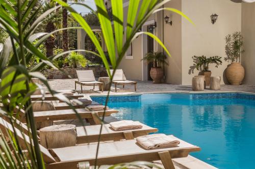 una piscina con tumbonas junto a un complejo en La Signora Hotel en Lourdhata