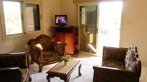 a living room with two chairs and a table at Chrysanthos Boutique Apartments in Limassol
