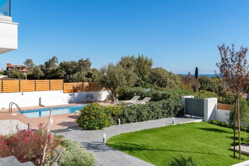 un jardín con piscina y césped en Terpsis Pool Villa en Rodas