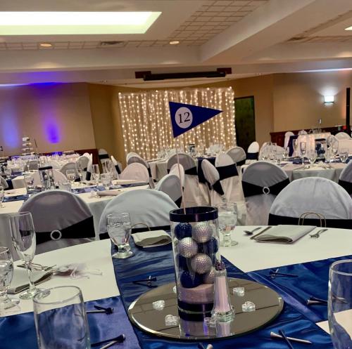 a conference room with tables and chairs with blue table cloth at Best Western Grand Victorian Inn in Sayre