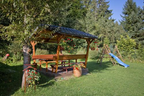a wooden gazebo in a yard with a playground at Drevenica pod Lánom in Zuberec