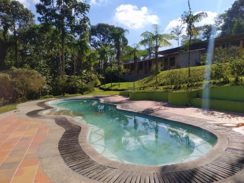 a swimming pool in a yard with a fountain at Mindo Loma bird lodge in Mindo