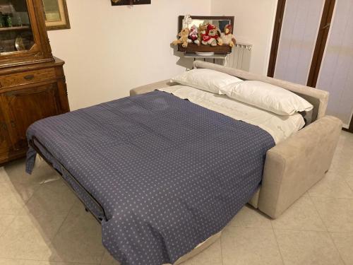 a bed with a blue blanket and pillows in a room at la nostra casa... in Novara