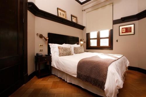 a bedroom with a large white bed and a window at Hotel Boutique Castillo Rojo in Santiago