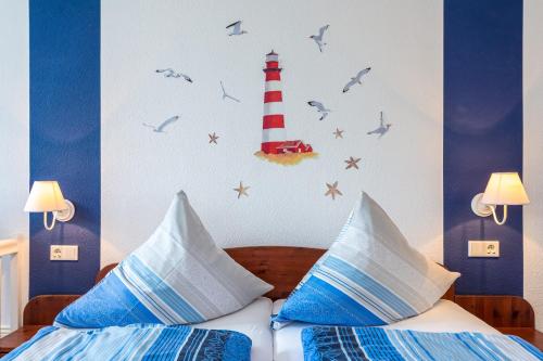 Schlafzimmer mit einem Bett und einem Leuchtturm an der Wand in der Unterkunft Inselhotel Arfsten in Wyk auf Föhr