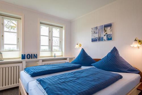 a bedroom with two blue pillows on a bed at Inselhotel Arfsten in Wyk auf Föhr