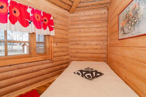 um chalé de madeira com uma cama num quarto em Karhunhovi em Pääjärvi