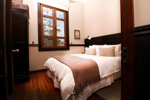 a bedroom with a large bed and a window at Hotel Boutique Castillo Rojo in Santiago