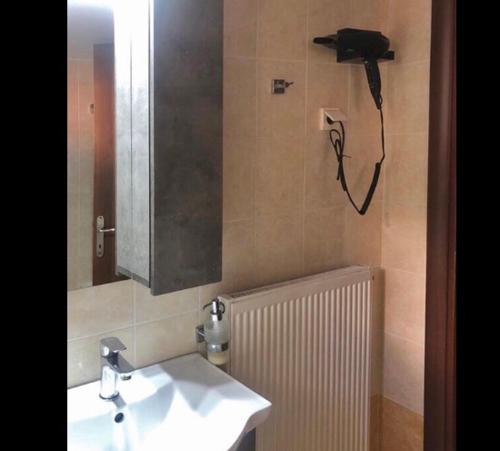 a bathroom with a sink and a mirror and a phone at Sweet Puzzle in Preveza