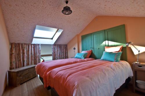 a bedroom with a large bed with red sheets and blue pillows at B&B A la Malogne in Mons