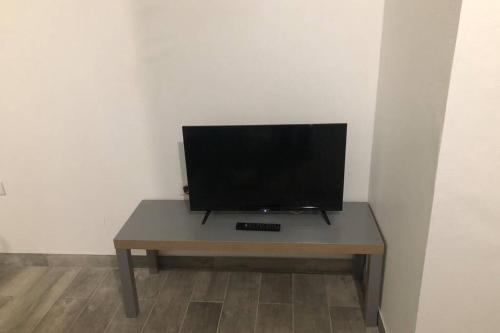 un téléviseur à écran plat posé sur une table dans l'établissement F2 au pied du château et à 15min de Center Parc, à La Ferté-Saint-Aubin