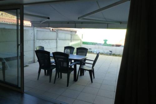 Une table à manger et des chaises sont disponibles sur la terrasse. dans l'établissement La Gabelle Saint Hilaire, à Saint-Pierre-des-Échaubrognes