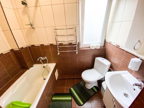 a bathroom with a toilet and a tub and a sink at Maria in Solochyn