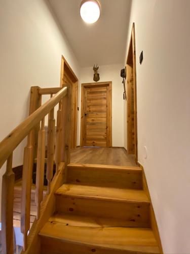a wooden staircase in a house with a door at Chalet Apartments Maštal in Železná Ruda
