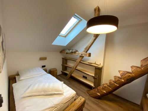 a bedroom with a bed and a window and a ladder at Chalet Apartments Maštal in Železná Ruda