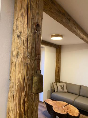 a living room with a couch and a wooden wall at Chalet Apartments Maštal in Železná Ruda