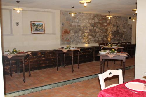 a restaurant with tables and chairs and a stone wall at Agriturismo BioBiò in Vobarno