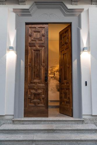 a large wooden door in a building with stairs at CA' DEL RE SCARTOZZ in Gavirate