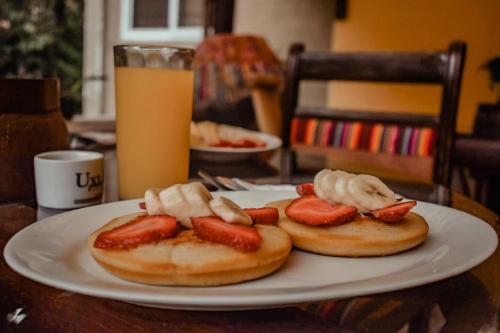 two hot dogs with strawberries and bananas on a plate at Eco Suites Uxlabil Guatemala in Guatemala