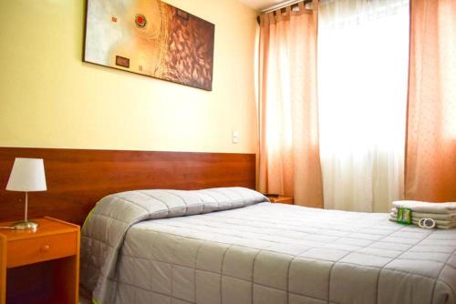 a hotel room with a bed and a window at Hotel Plaza Colon in Arica