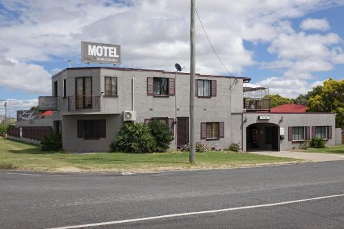 a large building with a sign on the side of it at Warwick Vines Motel in Warwick