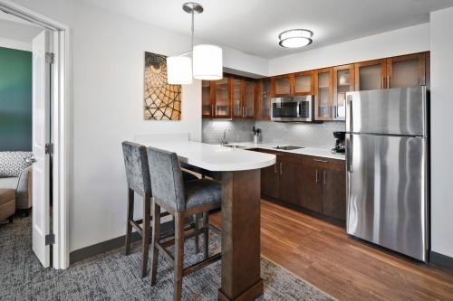 a kitchen with a table and chairs and a refrigerator at Staybridge Suites Irvine - John Wayne Airport by IHG in Irvine