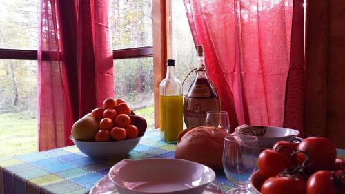 a table with a bottle of wine and a bowl of fruit at Agricampeggio Madonna di Pogi in Bucine