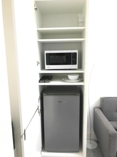 a small kitchen with a microwave and a refrigerator at Apartment style Space in Minworth