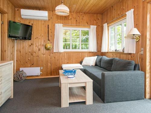 a living room with a couch and a tv at 4 person holiday home in Ansager in Ansager