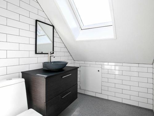 a bathroom with a sink and a skylight at Apartment Løkken in Løkken
