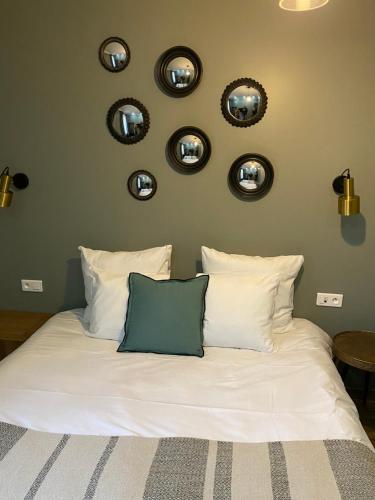 a bedroom with a bed with four mirrors on the wall at Le Grand Albert 1er in Maisons-Alfort