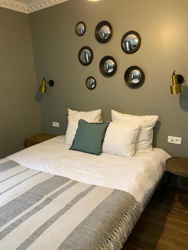 a bedroom with a bed with plates on the wall at Le Grand Albert 1er in Maisons-Alfort