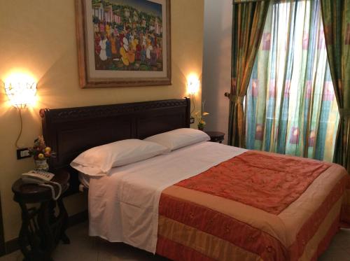 1 dormitorio con 1 cama, 2 lámparas y ventana en Albergo Verdi, en Palermo