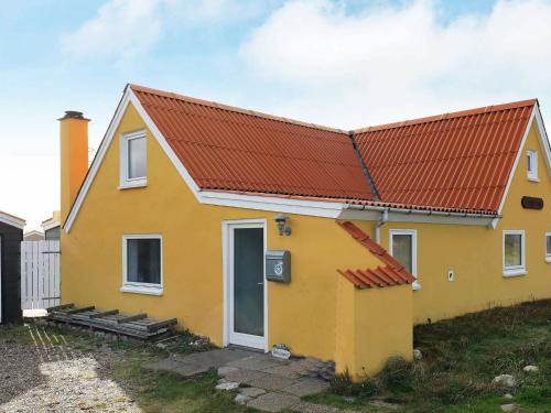 een geel huis met een oranje dak bij 6 person holiday home in Lemvig in Ferring