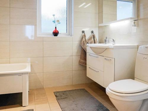 a bathroom with a toilet and a sink and a window at 10 person holiday home in KLÖVEDAL in Klövedal