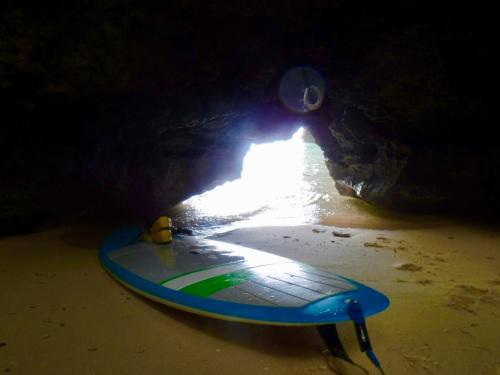 a surfboard sitting on the beach in a cave at Happy Island Miyako in Miyako Island