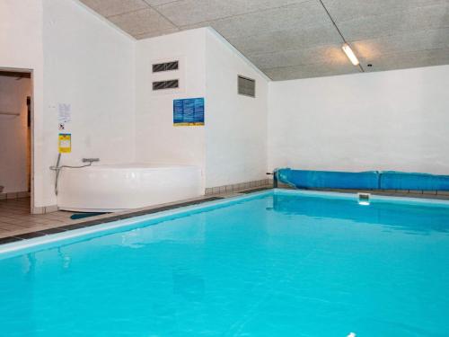 a large swimming pool with a tub and a bath room at 8 person holiday home in Knebel in Knebel