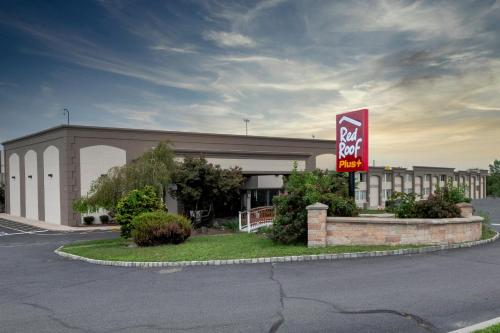 a large building with a sign in front of it at Red Roof PLUS Newark Liberty Airport - Carteret in Carteret