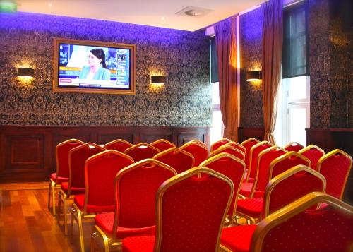 Cette chambre dispose de fauteuils rouges et d'une télévision murale. dans l'établissement Jackson Court Hotel, à Dublin
