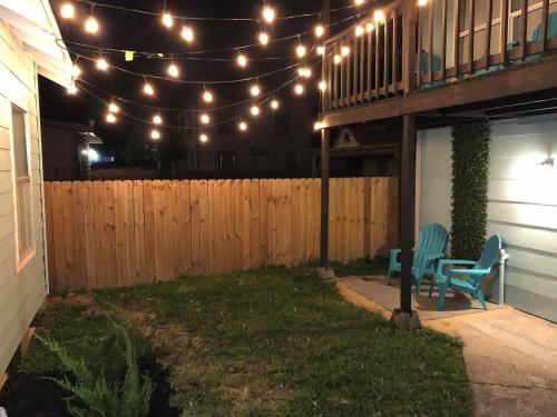 a patio with a chair and lights and a fence at The Comfi Coral - Large 1 Bedroom Studio A in Baytown